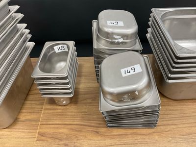 many trays of food sitting on a wooden table