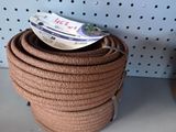 a stack of brown rope sitting on a shelf next to a pair of shoes