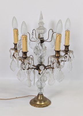 une image représentant un lustre à trois branches orné de pendentifs en cristal