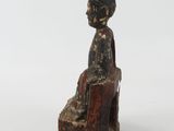 an old wooden statue of a woman sitting on a chair