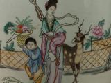 a vase that has a woman and a deer on it
