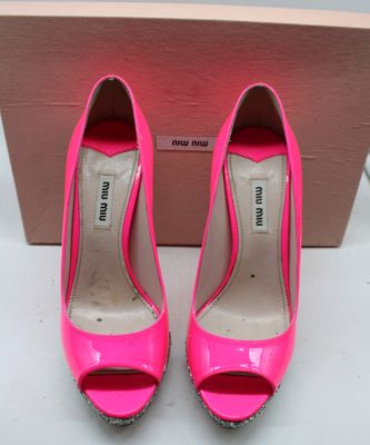 un gros plan sur une paire de chaussures roses posées sur une boîte