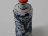 a small blue and white bottle with a dragon on it