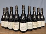 six bottles of wine are lined up on a wooden table