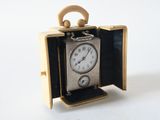 a small clock inside of a wooden box on a white surface