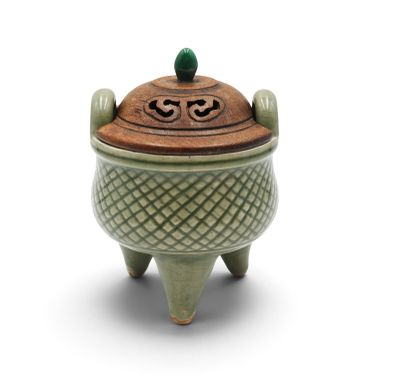 a small green pot with a lid on a white surface