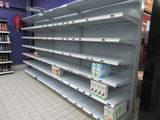 many empty shelves in a store with drinks on them
