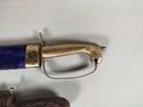 a purple and gold sword on a white surface