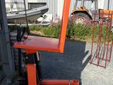 a fork lifter sitting on a pallet in front of a building