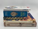trois livres empilés sur une surface blanche