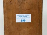 an old wooden box with a label on it sitting on a white surface