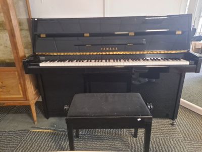 a black piano and a stool in a room