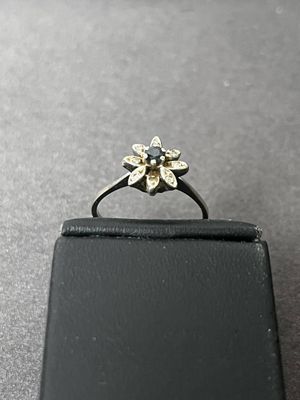 Bague fleur en or gris 750 centrée d'un petit saphir dans un…