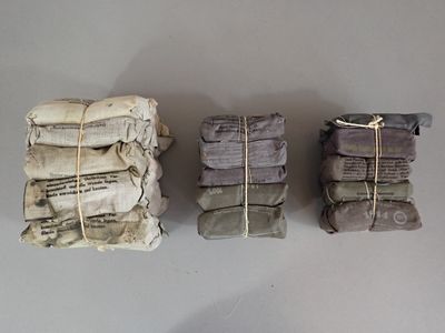 three stacks of newspapers wrapped in twine and tied with twine
