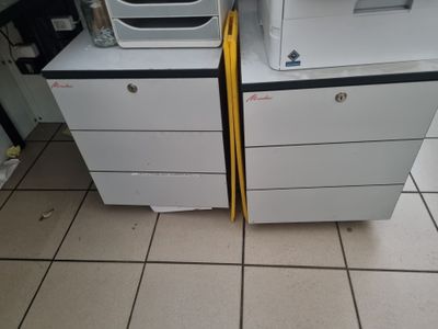 deux fours à micro-ondes empilés l'un sur l'autre, posés sur un sol carrelé