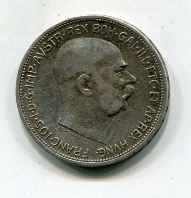 une vieille pièce de monnaie avec un visage d'homme sur une surface blanche