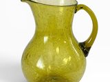pichet en verre jaune avec une anse noire sur fond blanc