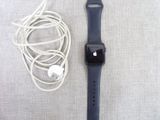 une Apple Watch et des écouteurs posés à côté d'un chargeur