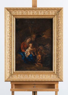 une image représentant un tableau posé sur un chevalet, sur lequel figure une femme tenant un enfant dans ses bras