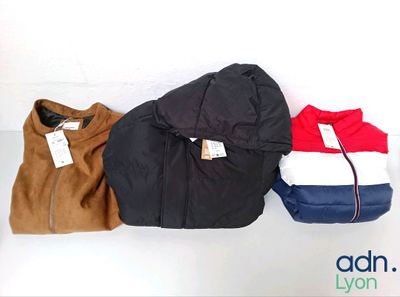 trois vestes sont alignées sur une surface blanche, avec une étiquette de prix accrochée à chacune d'elles