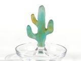a glass bowl with a cactus in it on a white surface