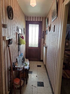 a hallway with a door, a mirror, and a chair in it