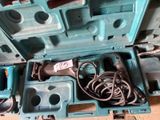 une boîte à outils bleue posée par terre, contenant des outils