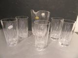quatre verres et un pichet posés sur une table