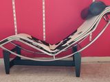 a black and white chaise lounger against a red wall