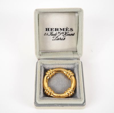 un gros plan d'une bague en or dans un écrin posé sur une surface blanche