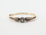 a gold and diamond ring with a flower design on the side