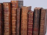 many old books that are stacked together on a table