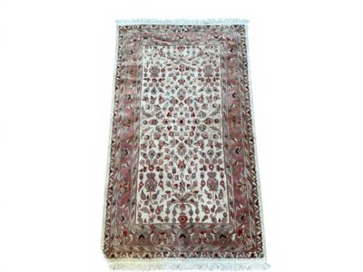 un tapis blanc bordé de rouge et orné d'un motif floral