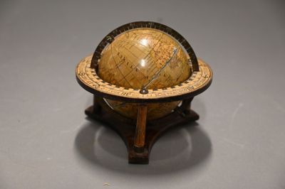 a small globe that is on a stand on a table