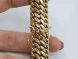 a close up of a person ' s hand holding a gold bracelet