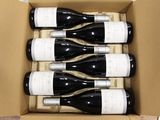 six bottles of wine in a cardboard box on a table