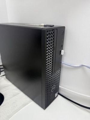 a black computer sitting on a white surface next to a mouse