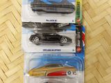 three hot wheels cars in the package on the table
