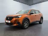 une voiture orange garée dans une grande pièce aux murs blancs