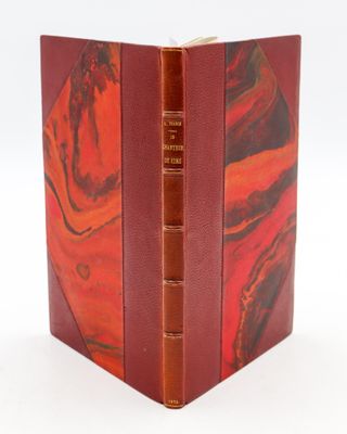an old book with a red cover and a brown cover