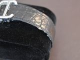 a black cuff with a silver buckle on top of it