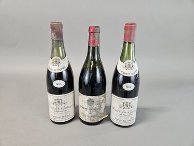 trois bouteilles de vin sont alignées sur une table
