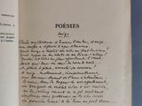 un livre ouvert, sur lequel on peut lire des mots, posé sur une surface bleue