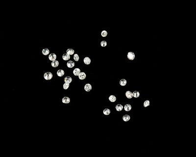 black and white photograph of a bunch of diamonds on a black surface