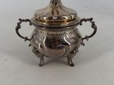 an antique silverplated sugar dish with a lid and handles