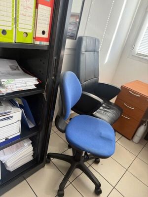 a blue office chair sitting in front of a bookcase