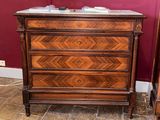 an antique chest of drawers with marble top in a room