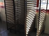 several trays of food sit on a metal rack in front of a window