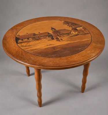 une table en bois sur laquelle est posée une image représentant une ferme