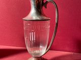 un pichet ancien en verre plaqué argent sur fond rouge